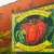 a brick wall with a painting of a vegetable on it