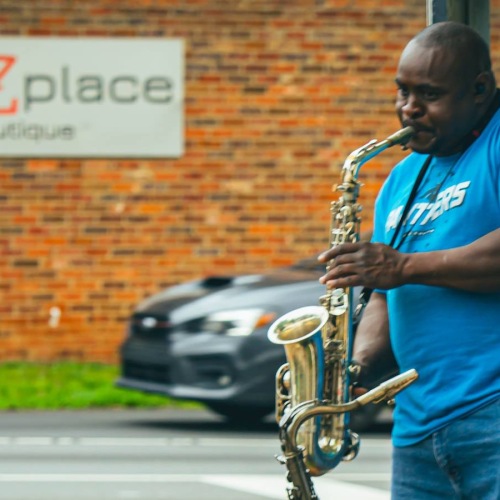 Bustling community life a man standing on a street corner playing an instrument