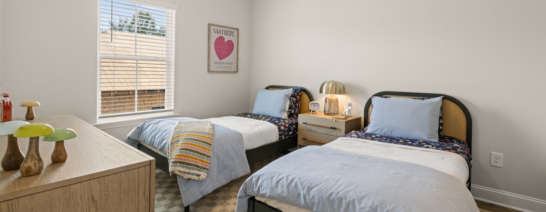 bedroom with a large window, two beds and a dresser