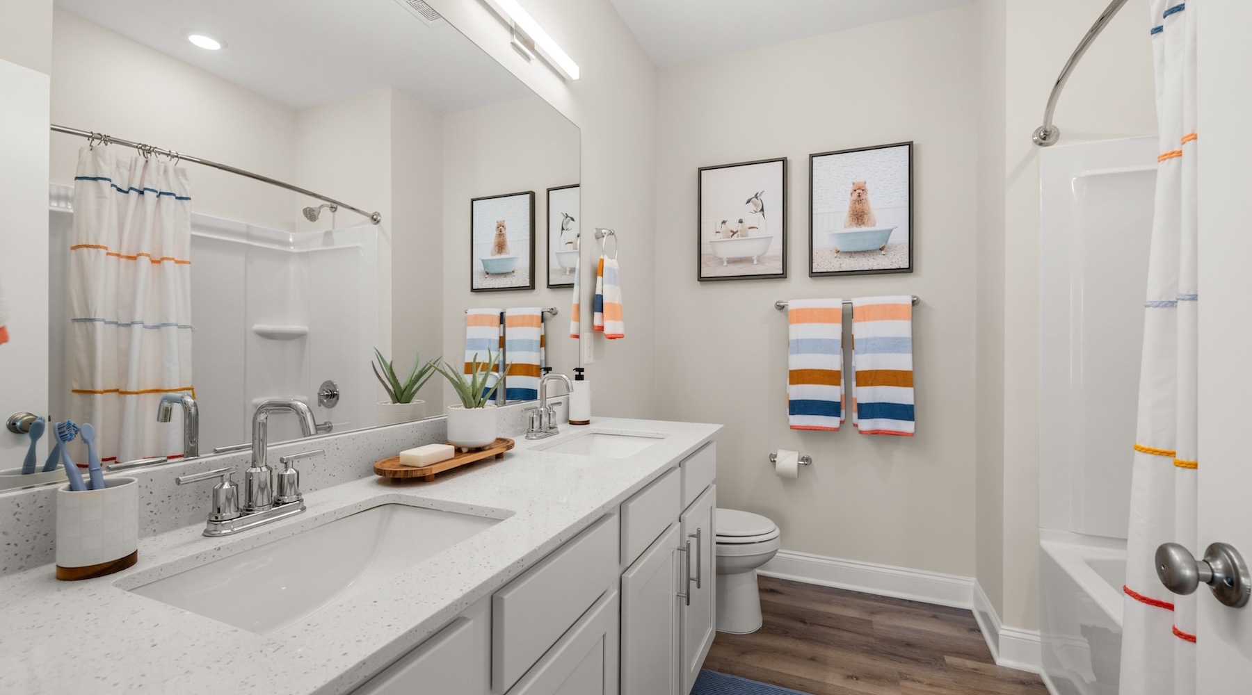 a bathroom with a large mirror, sink, shower, and toilet