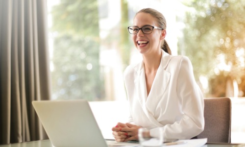 a woman smiling with a computer