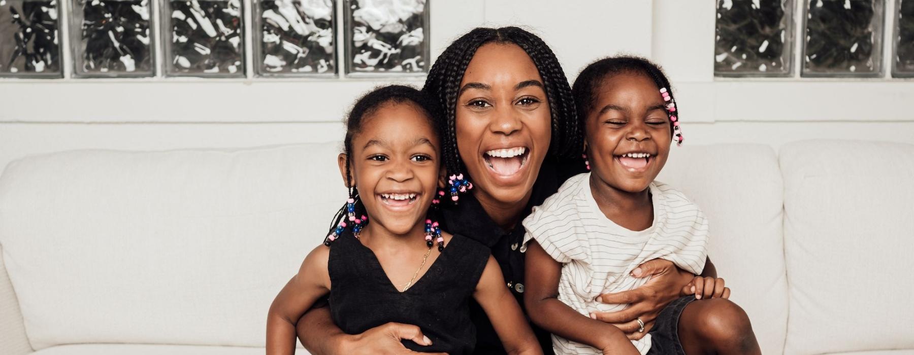 a woman sitting on a couch with two kids